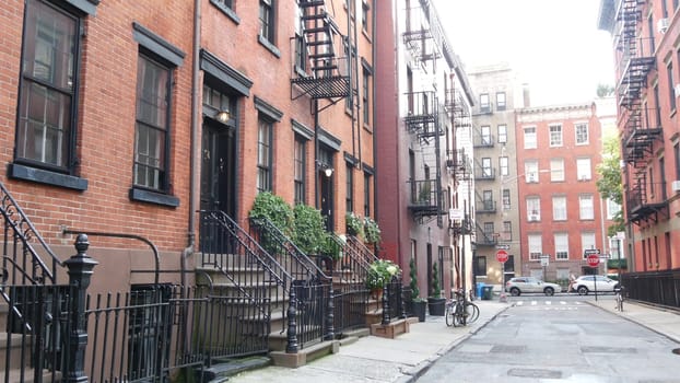 New York City, United States - 10 Sept 2023: Building architecture. Urban residential house exterior. Real estate property, USA. Red brick facade. Greenwich Village Gay street. Fire escape ladder exit