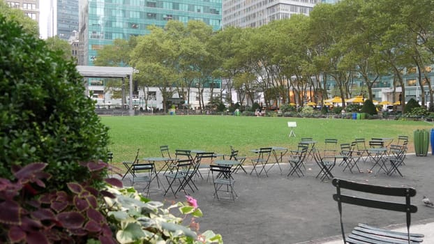 New York City, United States - 13 Sept 2023: Manhattan Midtown Bryant Park with Public library, 42 street and Fifth 5 avenue. USA landmark. Empty chair and table in summer greenery. Green grass lawn.