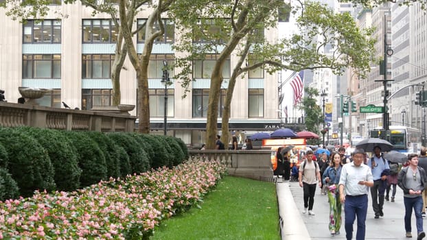 New York City, United States - 13 Sept 2023: Manhattan Midtown, Fifth 5 avenue. 42 street intersection corner near Bryant Park and Library, USA. American urban traffic, people pedestrian on rainy day.