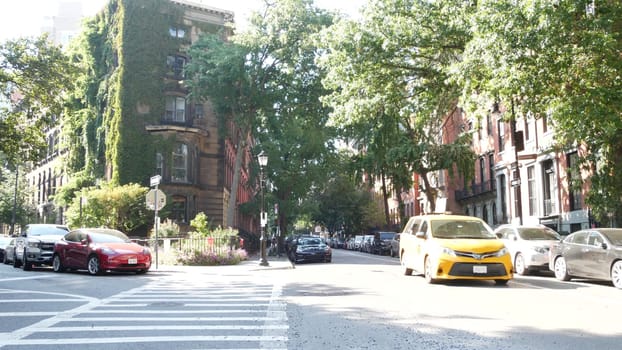 New York City, United States - 6 Sept 2023: Lower Manhattan East Village Stuyvesant street corner, crossroad intersection, USA. People, Yellow taxi cab. Residential house wall covered ivy plant leaves