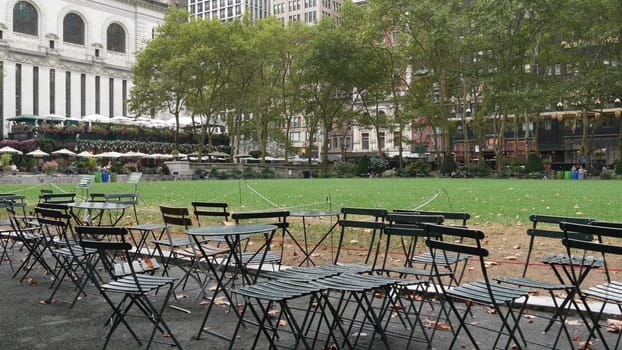 New York City, United States - 13 Sept 2023: Manhattan Midtown Bryant Park with Public library, 42 street and Fifth 5 avenue. USA landmark. Empty chair and table in summer greenery. Green grass lawn.