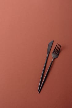 Knife and fork, cutlery on a brown dining table. Utensils and crockery for preparing dinner