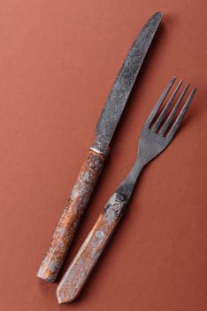 Knife and fork, cutlery on a brown dining table. Utensils and crockery for preparing dinner