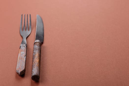 Knife and fork, cutlery on a brown dining table. Utensils and crockery for preparing dinner