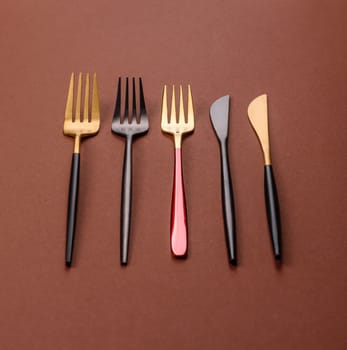 Knife and fork, cutlery on a brown dining table. Utensils and crockery for preparing dinner