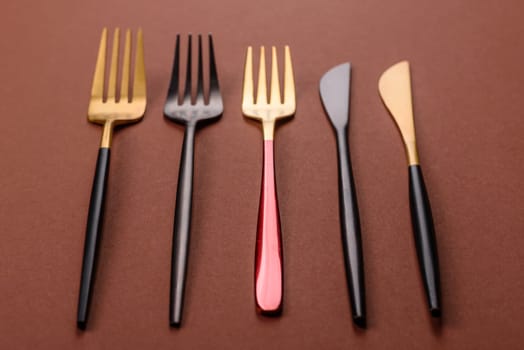 Knife and fork, cutlery on a brown dining table. Utensils and crockery for preparing dinner