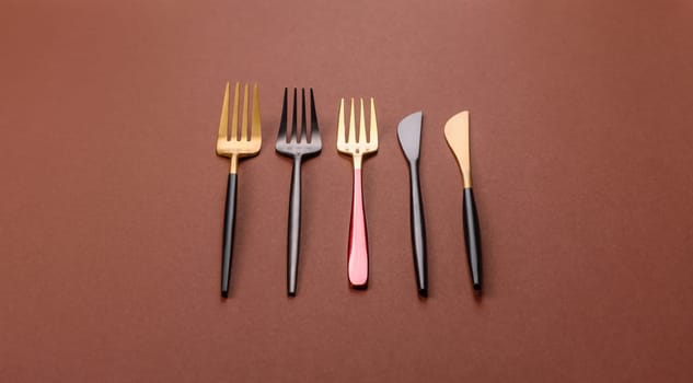 Knife and fork, cutlery on a brown dining table. Utensils and crockery for preparing dinner