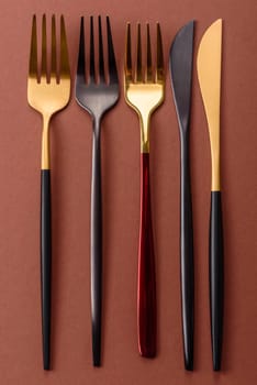 Knife and fork, cutlery on a brown dining table. Utensils and crockery for preparing dinner