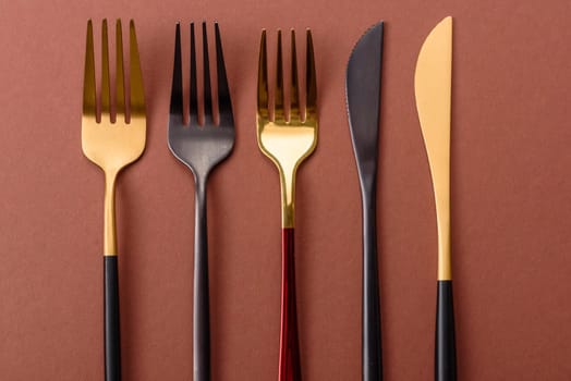 Knife and fork, cutlery on a brown dining table. Utensils and crockery for preparing dinner