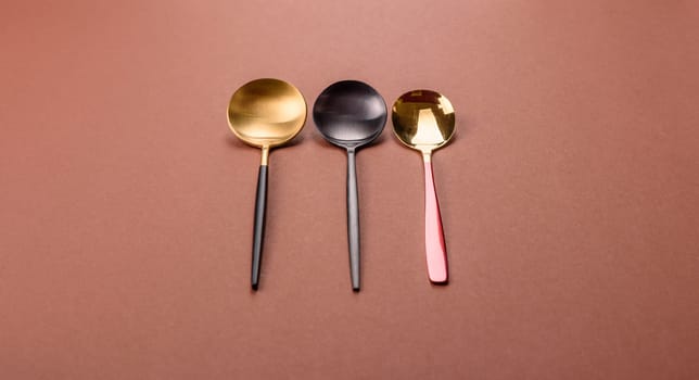 Empty metal spoon on a monochrome brown background. Cutlery on the dining table