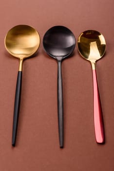 Empty metal spoon on a monochrome brown background. Cutlery on the dining table