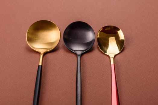 Empty metal spoon on a monochrome brown background. Cutlery on the dining table