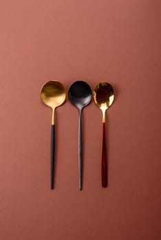 Empty metal spoon on a monochrome brown background. Cutlery on the dining table