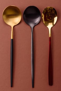 Empty metal spoon on a monochrome brown background. Cutlery on the dining table