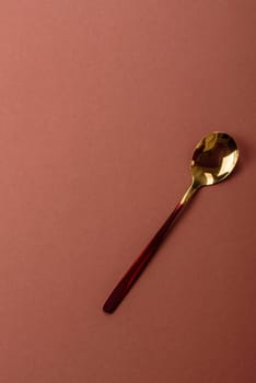 Empty metal spoon on a monochrome brown background. Cutlery on the dining table