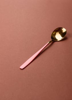 Empty metal spoon on a monochrome brown background. Cutlery on the dining table