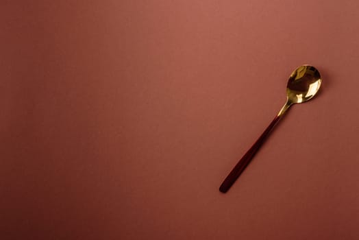 Empty metal spoon on a monochrome brown background. Cutlery on the dining table