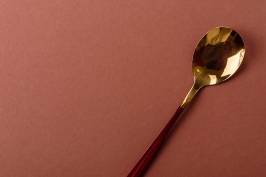 Empty metal spoon on a monochrome brown background. Cutlery on the dining table