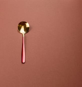 Empty metal spoon on a monochrome brown background. Cutlery on the dining table