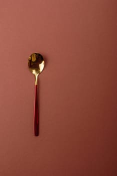 Empty metal spoon on a monochrome brown background. Cutlery on the dining table