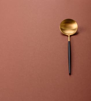Empty metal spoon on a monochrome brown background. Cutlery on the dining table