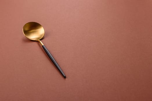 Empty metal spoon on a monochrome brown background. Cutlery on the dining table