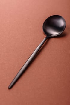 Empty metal spoon on a monochrome brown background. Cutlery on the dining table
