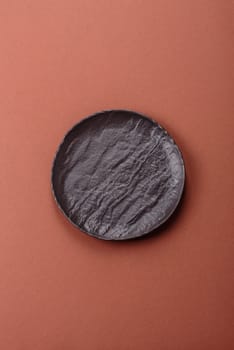 Empty ceramic plate on a monochrome brown background. Empty plate with cutlery on a dining table