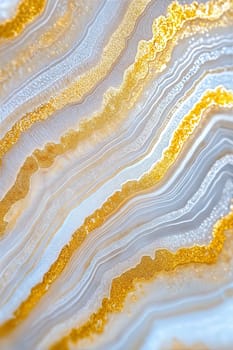 Top-down close-up of stunning light grey agate with rich golden veins. This background features intricate textures and natural patterns, perfect for luxury designs.