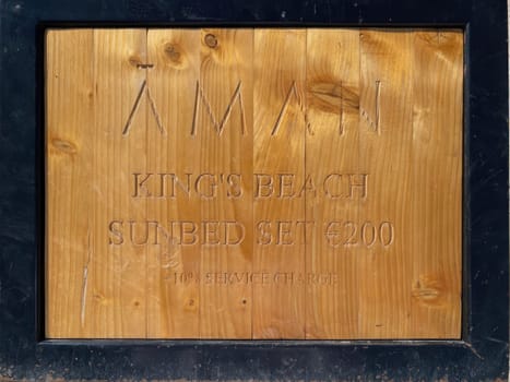 Sveti Stefan, Montenegro-September 17, 2023: wooden sign with price for sunbed -200 euros