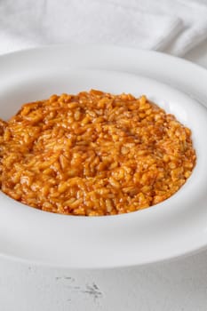 Tomato risotto plated simply with vibrant warmth