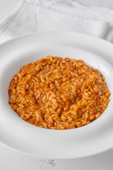 Tomato risotto plated simply with vibrant warmth