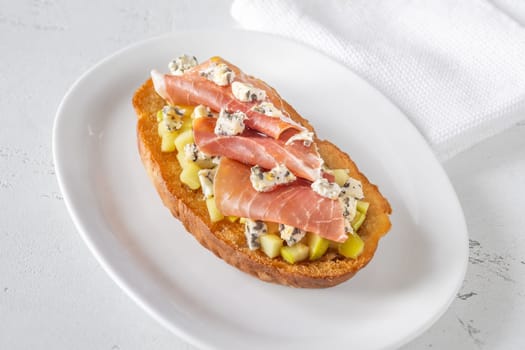 Warm sandwich stacked with creamy cheese, salty ham, sweet apple, and honey