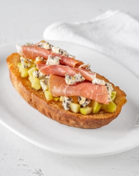 Warm sandwich stacked with creamy cheese, salty ham, sweet apple, and honey