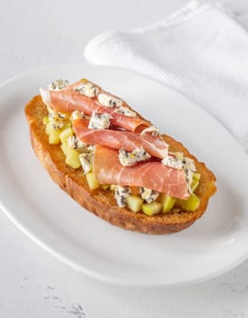 Warm sandwich stacked with creamy cheese, salty ham, sweet apple, and honey