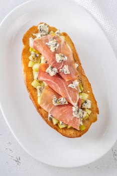 Warm sandwich stacked with creamy cheese, salty ham, sweet apple, and honey