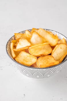 Crispy fried dippers rest warmly in bowl, perfect for salty snacking joy