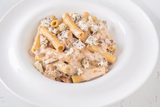 Soft penne coated in rich walnut sauce with crumbled sharp blue cheese