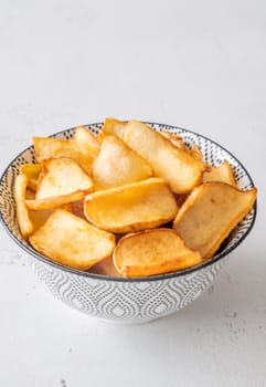 Crispy fried dippers rest warmly in bowl, perfect for salty snacking joy