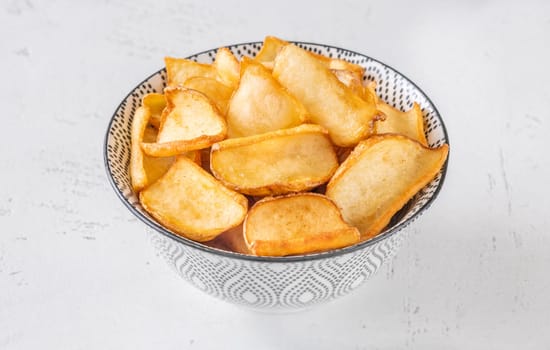 Crispy fried dippers rest warmly in bowl, perfect for salty snacking joy