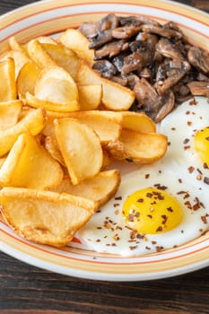 A hearty breakfast dish with crisp dippers, runny eggs, and sauteed mushrooms