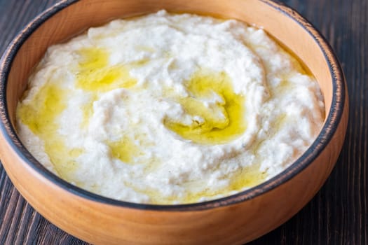 Roasted eggplant dip topped with chili flakes and oil in rustic setting