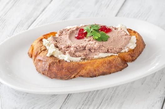 Toasted wheat sandwich with pate, creamy cheese, and tart cranberry jam