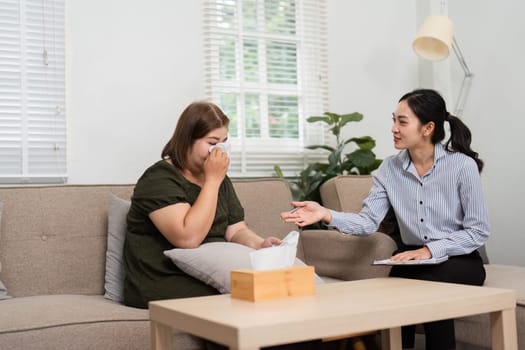 An understanding psychiatrist helps her patient navigate through tears, facilitating an open discussion surrounding difficult emotions and experiences in therapy.