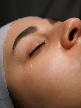 Anti-wrinkle moisturizing gel for the face around the eyes for the eyelids. Women's care at a beautician, close-up, vertical