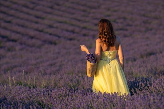 Here's a caption that fits your specifications: Woman in yellow dress walks through a vast lavender field at sunset. She carries a small woven bag. Purple flowers surround her.