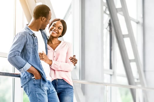 Ready For Romantic Travel. Black Couple In Love Waiting For Flight At Airport Terminal, Hugging And Smiling, Copy Space