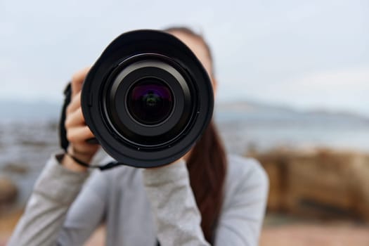 A passionate young woman photographer, capturing moments with a camera against a beautiful outdoor backdrop, reflecting creativity and love for photography
