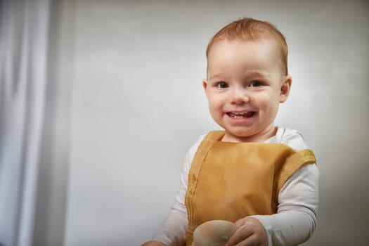 A boy explores the texture of flour while playing in a studio, showcasing a fun and creative cooking activity.