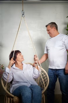 Couple shares a loving interaction while posing together in a warm and inviting indoor setting, highlighting their connection.